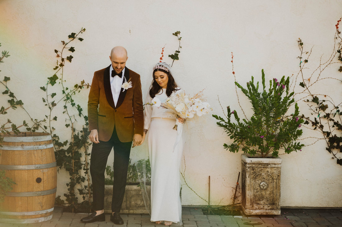 Couple holding hands on their wedding day at Folktale Winery in Carmel California taken by Santa Cruz wedding and elopement photographer and videographer 