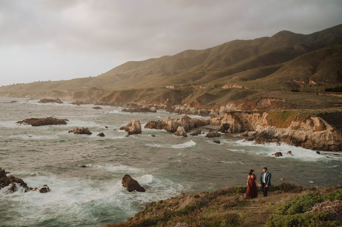 Garapatta State Park engagement session with couple on the cliffs with mountains in background overlooking the ocean