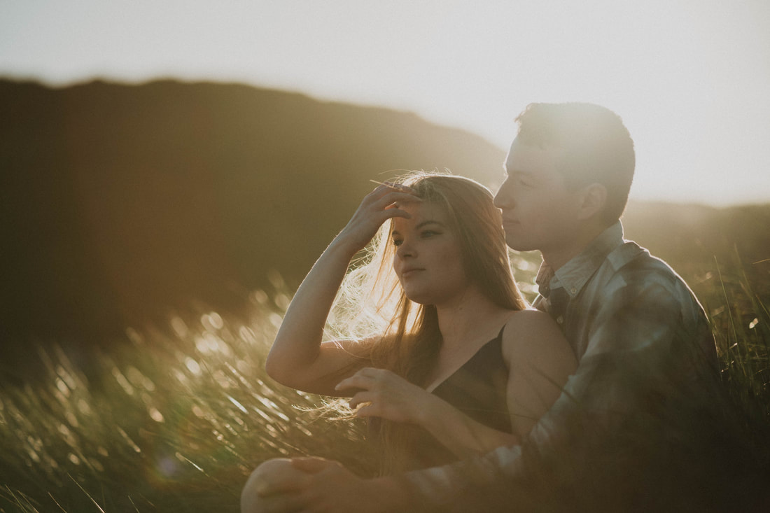 Couple sitting in grass in Santa Cruz California taken by Santa Cruz wedding and elopement photographer and videographer 