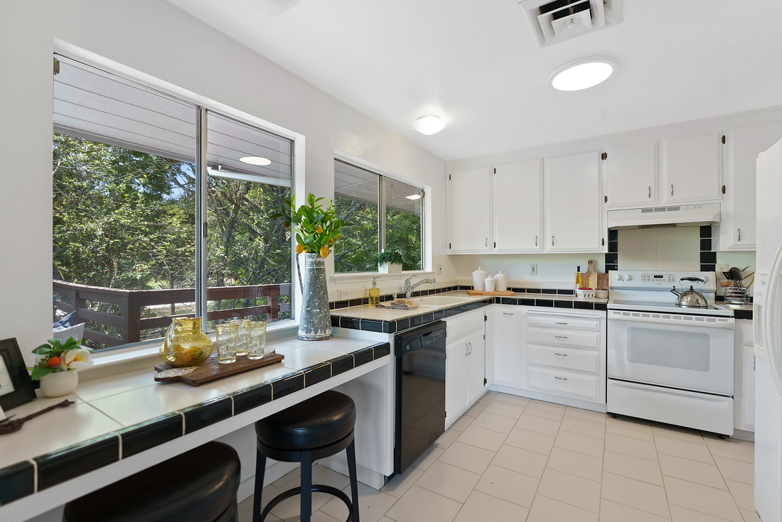 Spacious kitchen with forest view real estate photo.